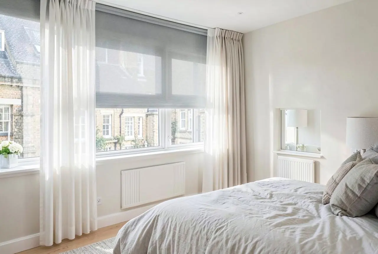 Motorised roller blind and sheer curtains in a bright London bedroom